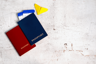 Two passports with boarding passes and paper airplane